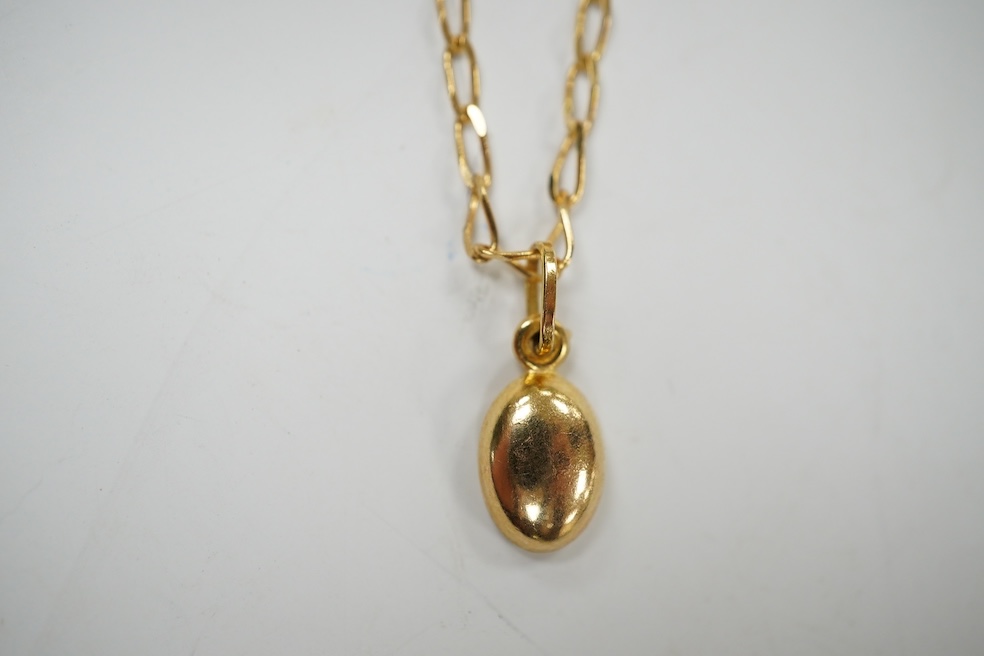 A modern 9k 'coffee bean' pendant, on an Italian 9k chain, overall 47cm, 2.9 grams. Condition - good